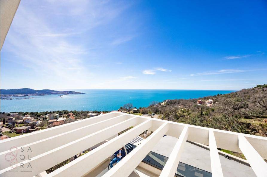 Dachterrasse mit Pergola-Struktur und weitem Blick auf das Meer und die umliegende Landschaft.