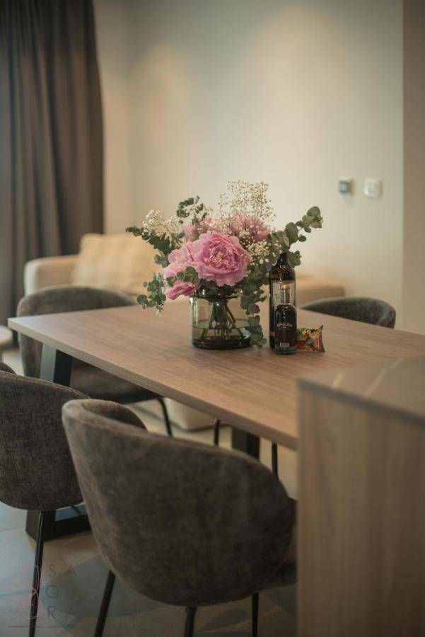 Eleganter Essbereich mit Holztisch, bequemen Stühlen und frischem Blumenarrangement.