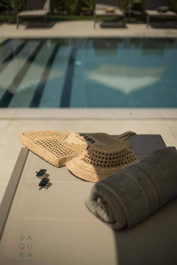 Detailaufnahme von Sonnenhut und Handtuch auf einem Liegestuhl am Poolbereich.