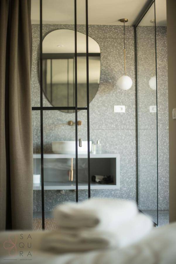 Stilvolles Badezimmer mit ovalem Spiegel, Hänge-Waschtisch und eleganter Glasabtrennung.