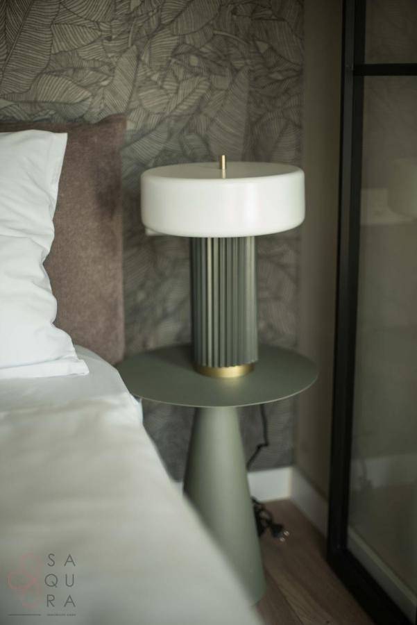 Modernes Schlafzimmer mit Nachttischlampe und stilvoller Tapete an der Wand.