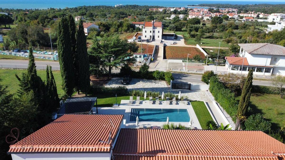 Weitläufige Ansicht der Villa mit Pool, umgeben von Natur und mit Blick auf das Meer in der Ferne.