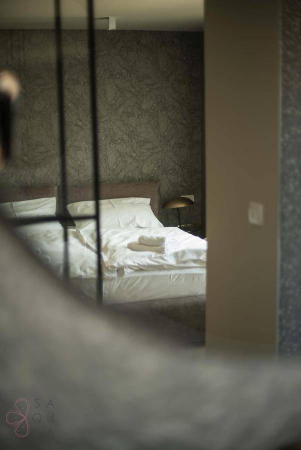 Gemütliches Schlafzimmer mit Doppelbett, weißer Bettwäsche und eleganter Nachttischlampe.