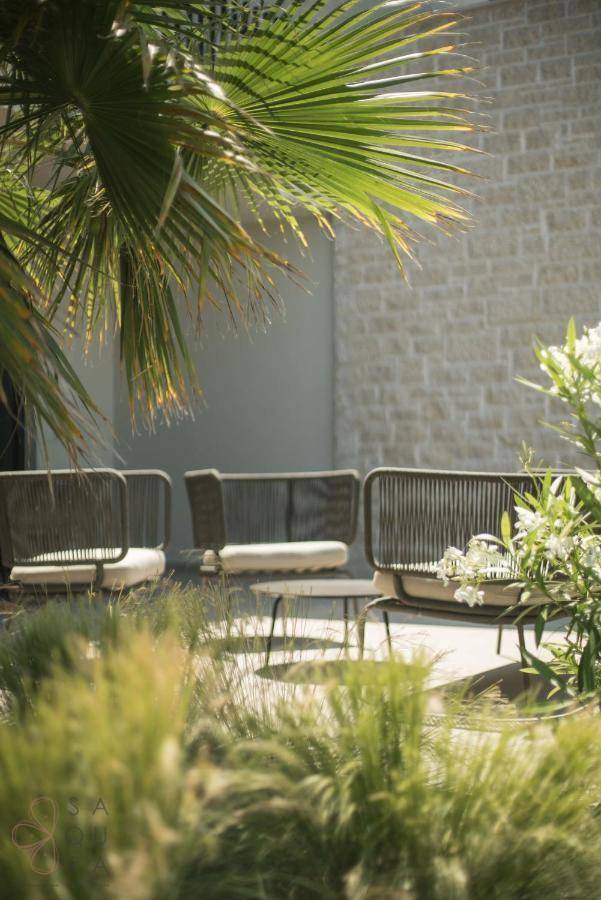 Gemütlicher Außenbereich mit Rattan-Sitzmöbeln und üppiger Bepflanzung im Garten.