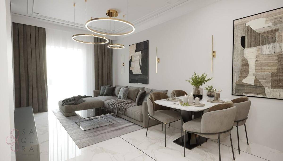 Eleganter Wohn- und Essbereich in Grautönen mit modernem Sofa und stilvoller Beleuchtung.