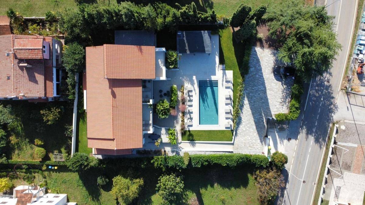 Gesamtansicht der modernen Villa von oben mit Pool, Garten und Zufahrt in einer ruhigen Umgebung.