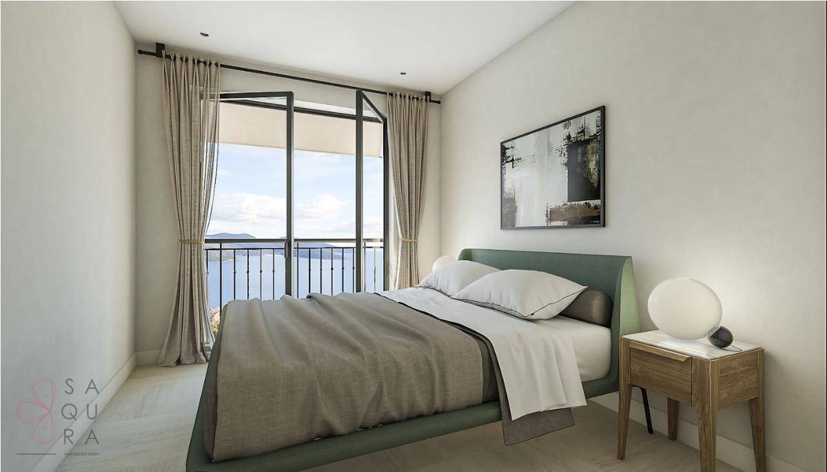 Schlafzimmer mit Doppelbett, Einbauschränken und direktem Zugang zum Balkon mit Meerblick.