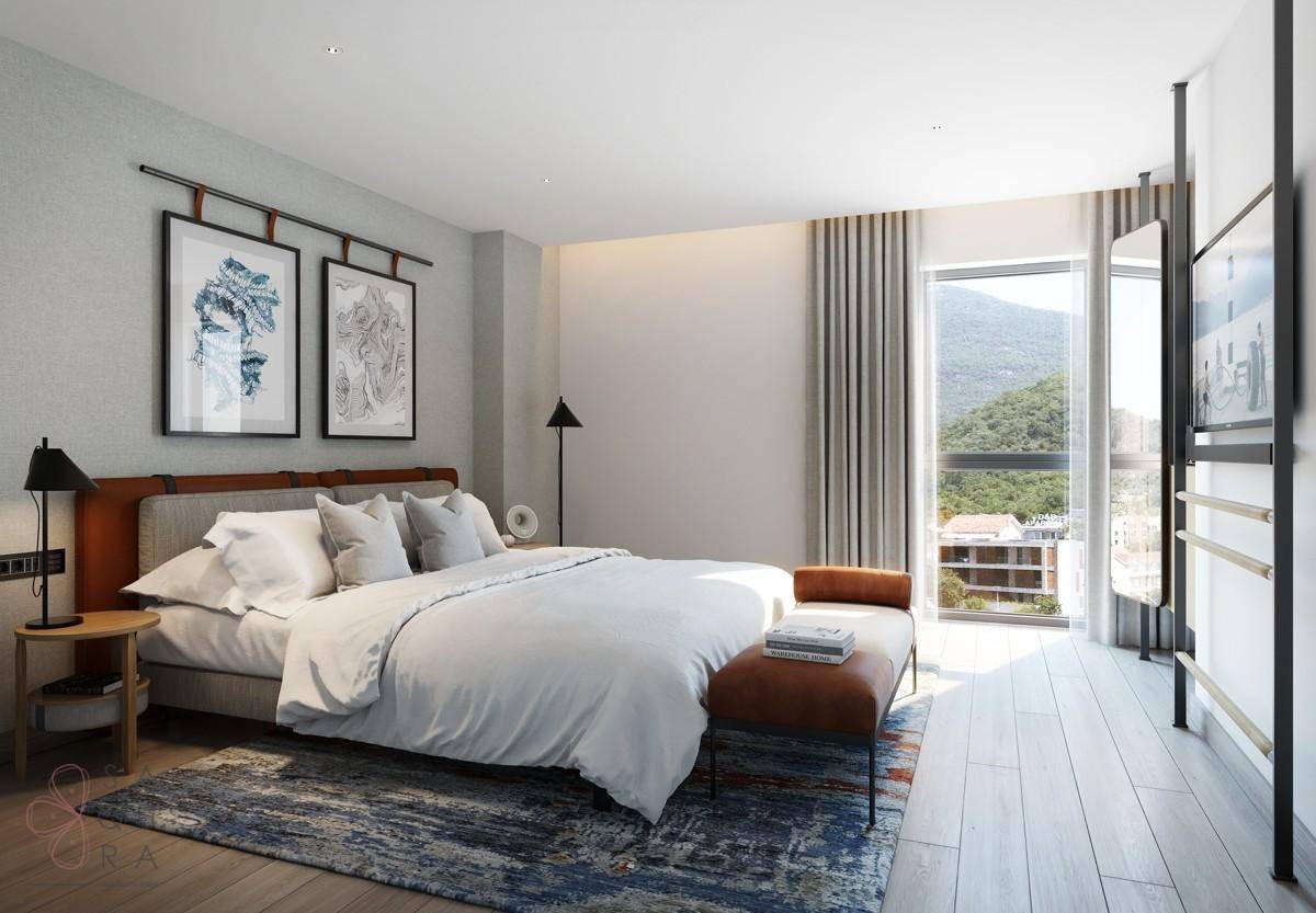 Helles Schlafzimmer mit Holzboden, großem Fenster und malerischem Bergblick.