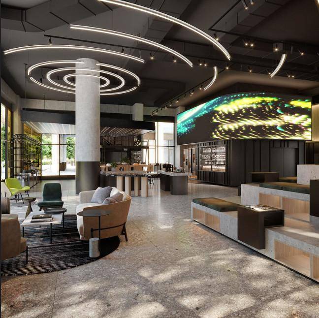 Moderne Lobby mit großem Bildschirm, bequemen Sitzbereichen und zeitgenössischem Design.