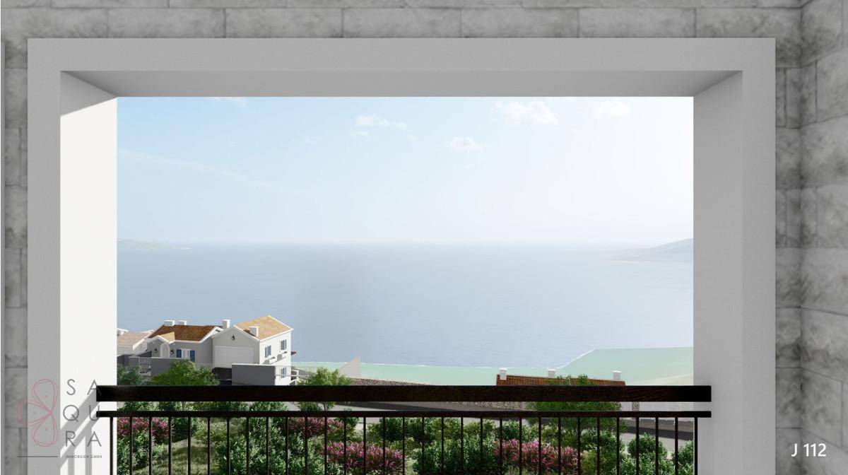 Blick von einem Balkon auf das weite Meer und die umliegende Küstenlandschaft.