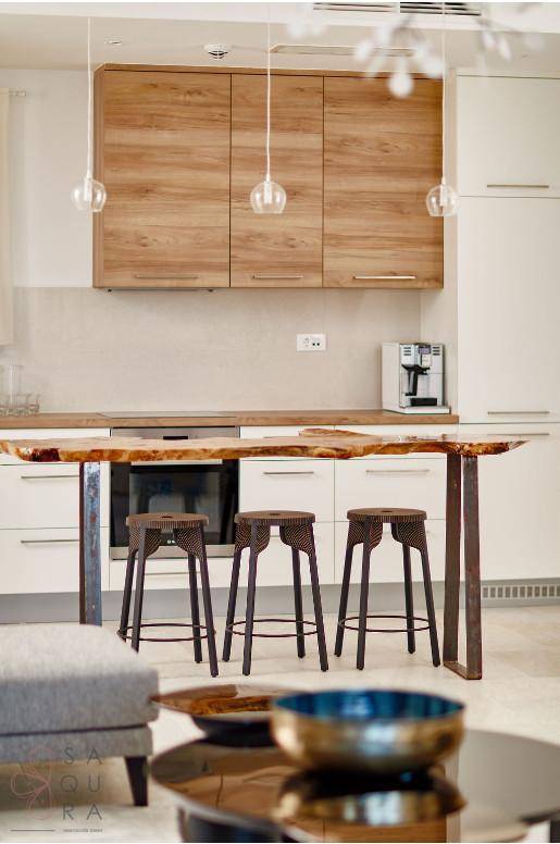Moderne Küche mit Holz- und weißen Schränken sowie einer einzigartigen Holztheke mit Barhockern.