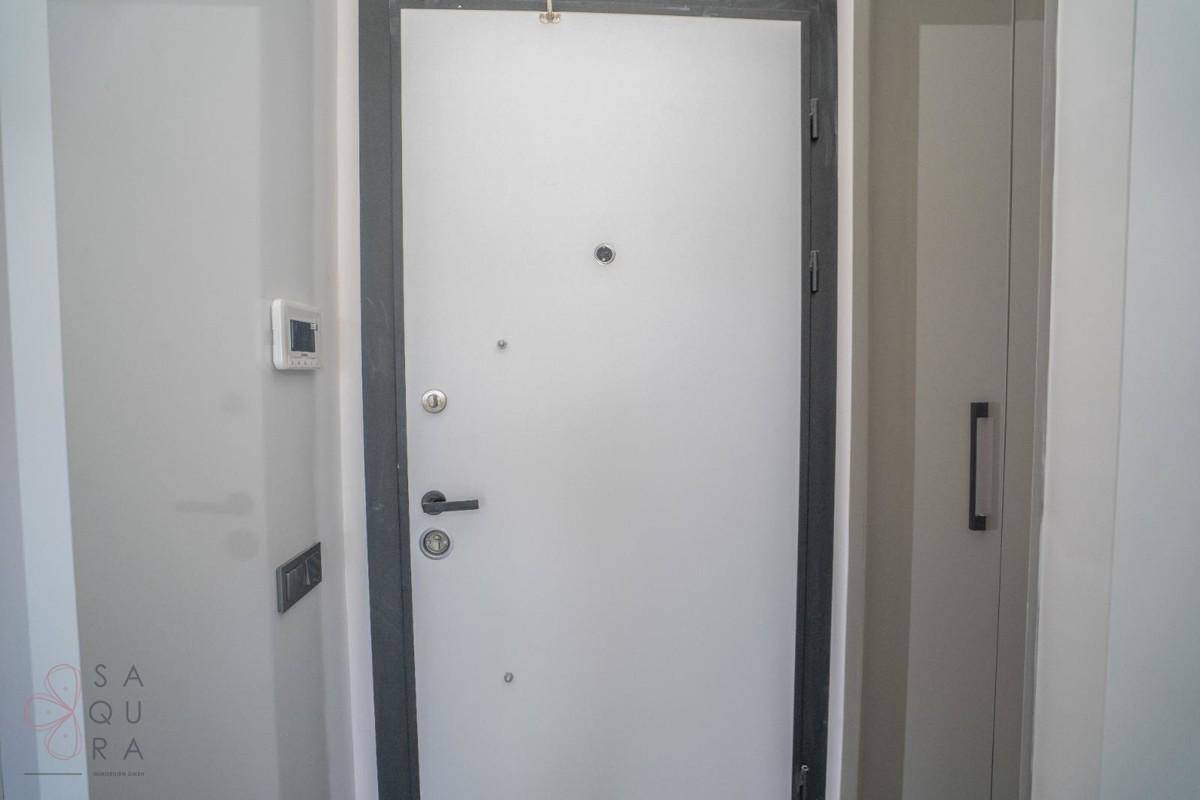 Moderne Eingangstür in einem hellen Flur mit minimalistischem Design und integriertem Schrank.