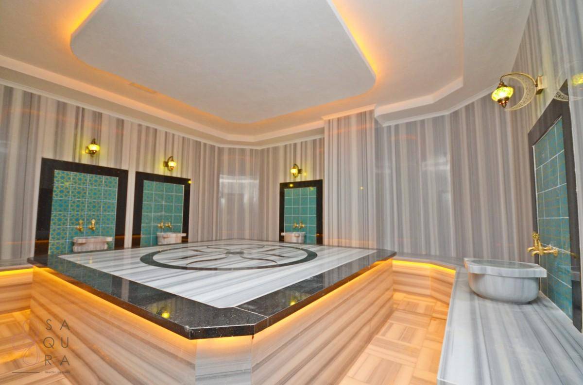 Luxuriöses türkisches Bad (Hammam) mit Marmoroberflächen und traditionellen Armaturen, ein Ort der Ruhe.