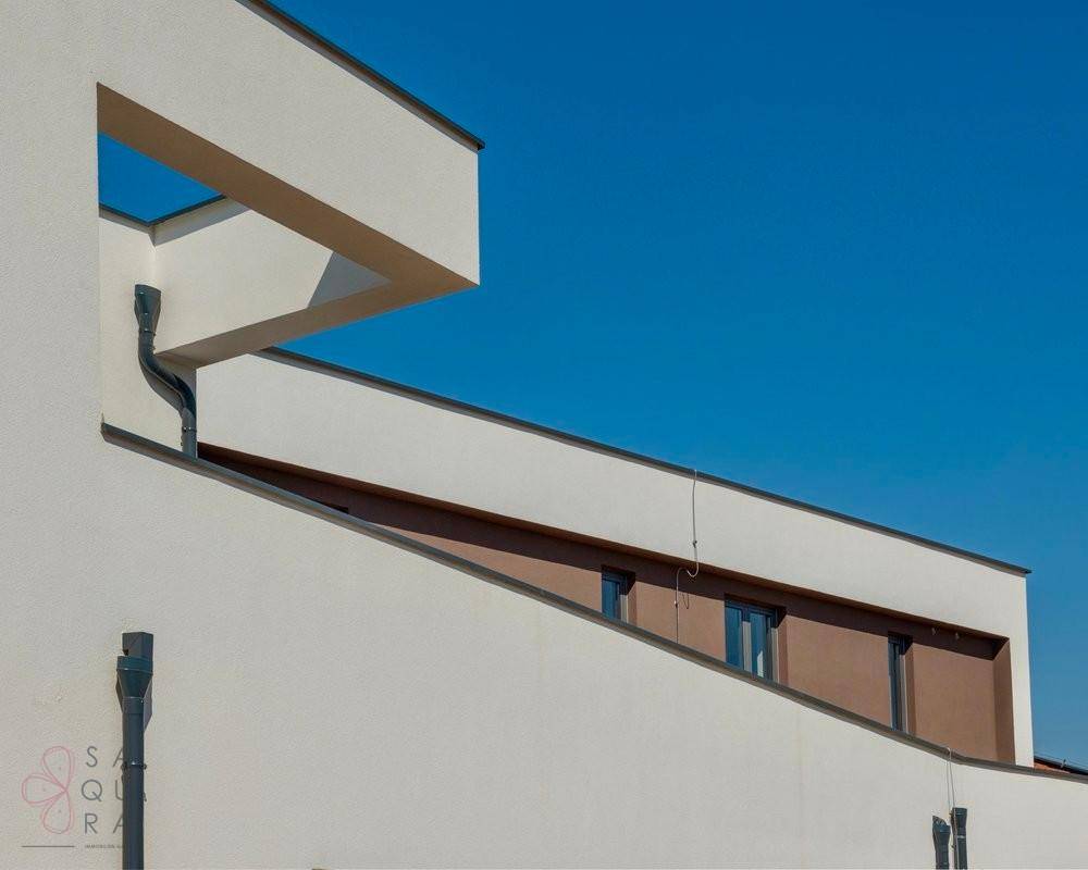 Architektonisches Detail der modernen Fassade mit klaren Linien und Entwässerungssystem.