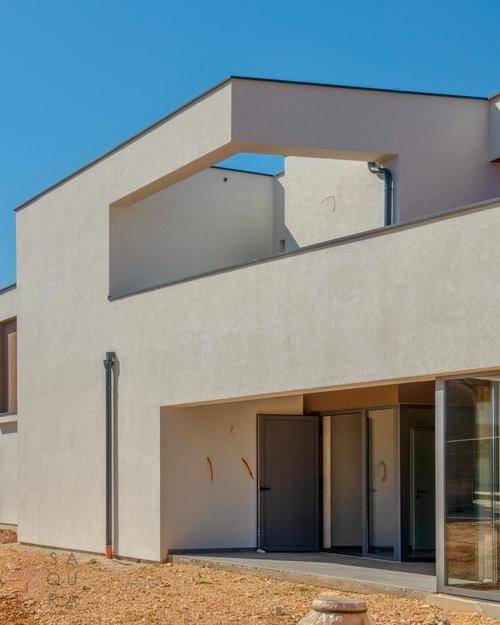 Eingangsbereich der modernen Villa mit großer Glasfront und schlichter Tür.