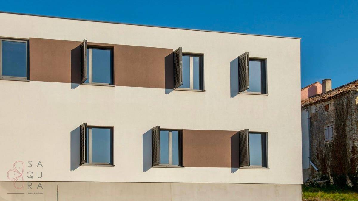 Fassadendetail der modernen Villa mit weißen Wänden, braunen Akzenten und Fensterläden.