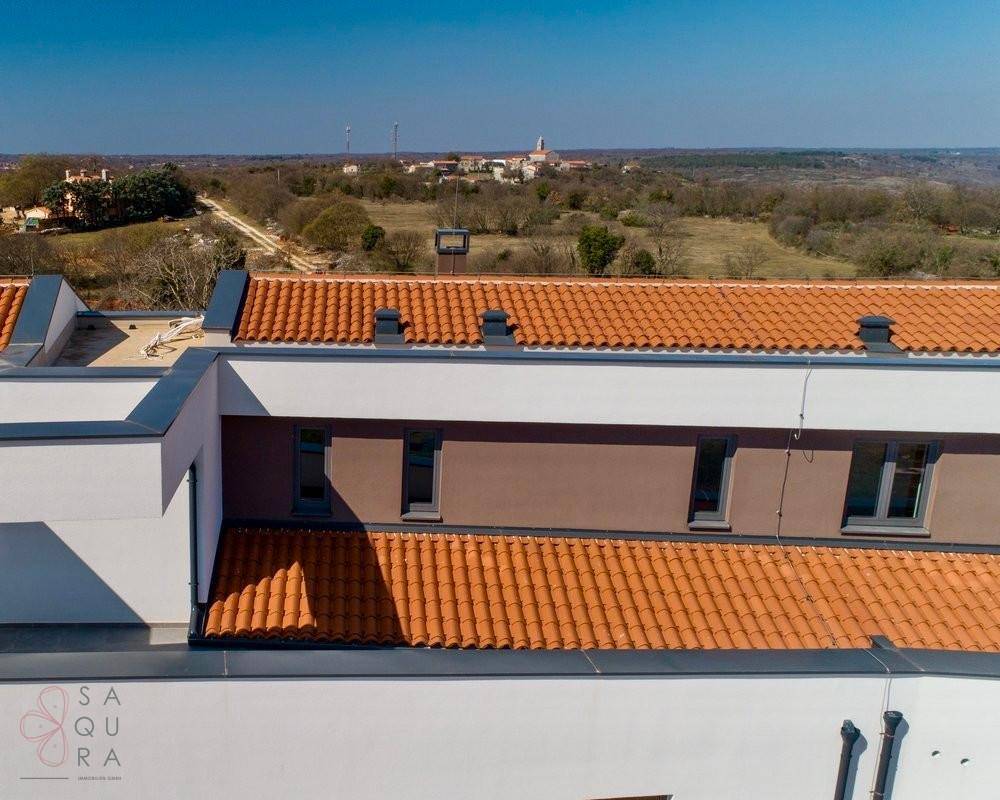 Dachansicht der modernen Villa mit traditionellen Ziegeln und weitem Blick über die Landschaft.