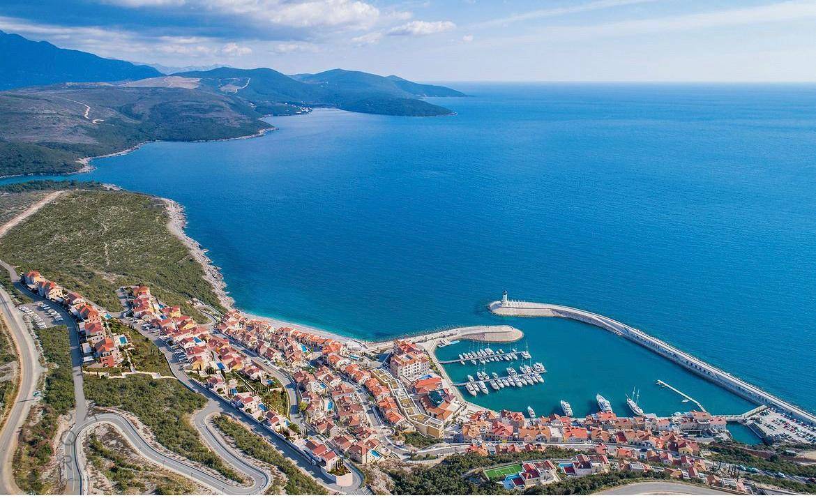 Malerische Küstenstadt mit Yachthafen und zahlreichen Gebäuden am Meer.