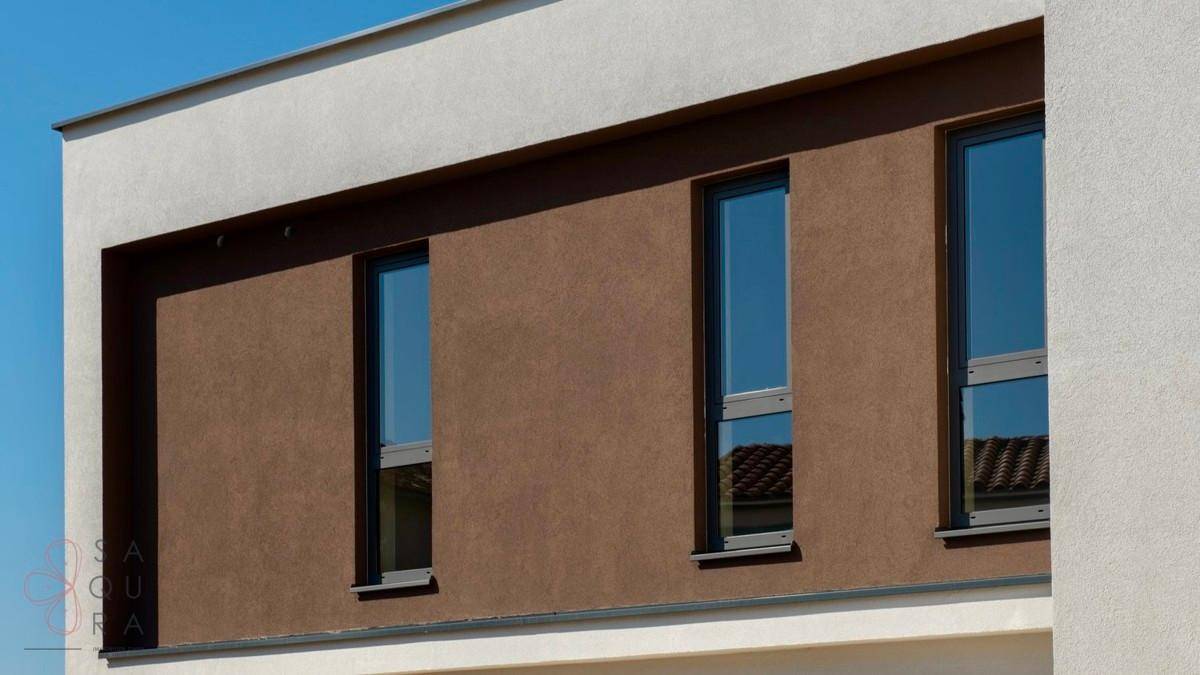 Vertikale Fenster in einer braunen Fassadenfläche der modernen Villa.