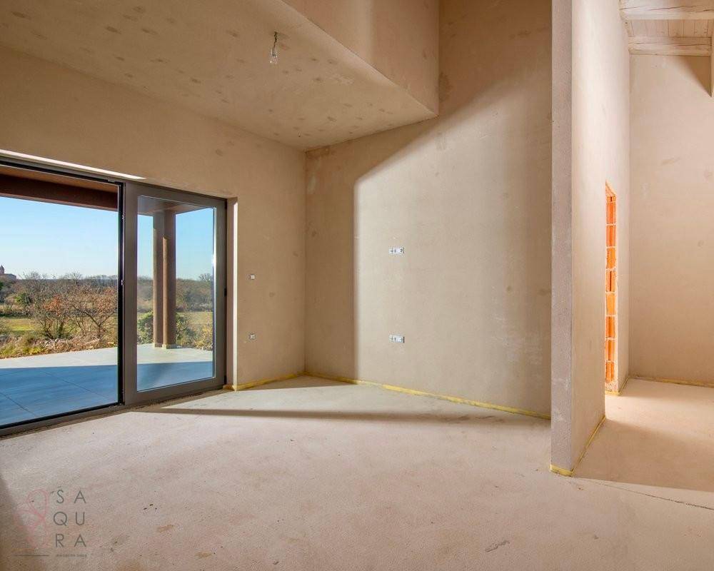 Heller, unfertiger Wohnbereich mit großen Schiebetüren und weitem Blick in die Landschaft.