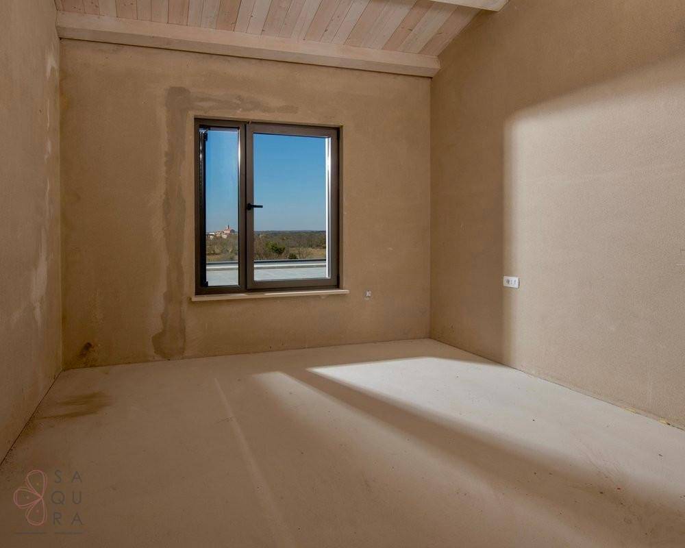 Unfertiges Zimmer mit Fenster und Blick auf die umliegende Natur, hell und ruhig.