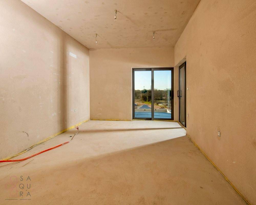 Unfertiges Zimmer mit Schiebetür zum Außenbereich und Blick ins Grüne, hell und geräumig.