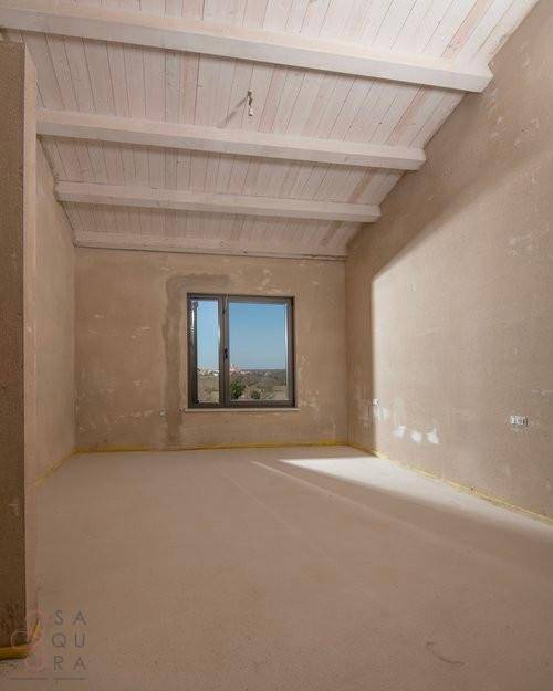Unfertiges Zimmer mit Dachschräge, Fenster und viel natürlichem Licht, ideal für Schlafzimmer.