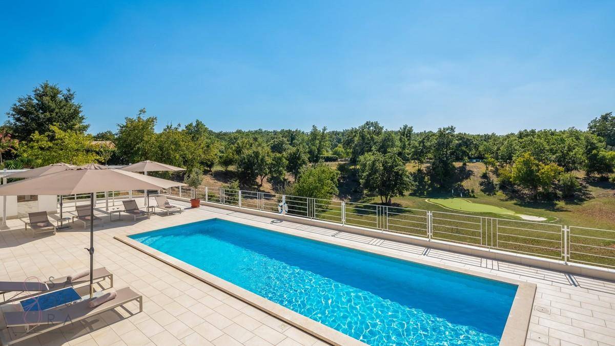 Weitläufiger Poolbereich mit klarem Wasser und Panoramablick auf die grüne Umgebung.