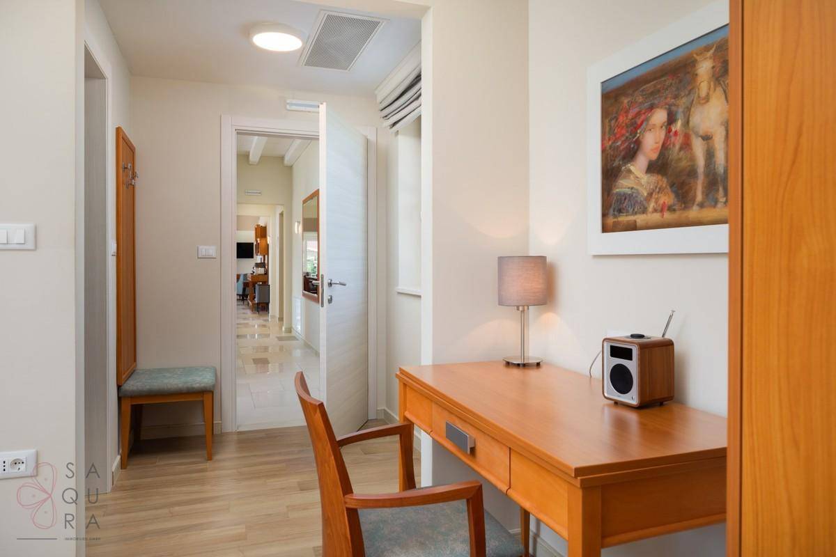 Kleiner Arbeitsbereich im Flur mit Schreibtisch, Stuhl und Holzboden.