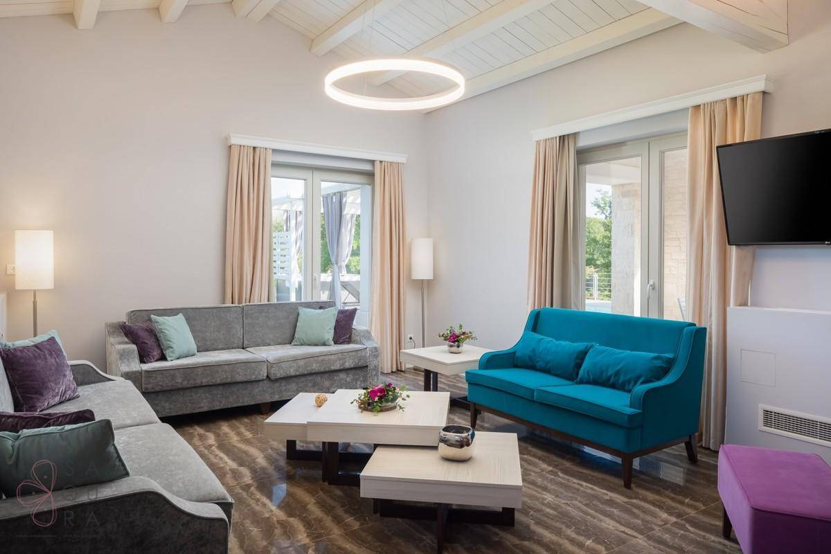 Helles Wohnzimmer mit hohen Decken, modernen Leuchten und stilvollen Möbeln.