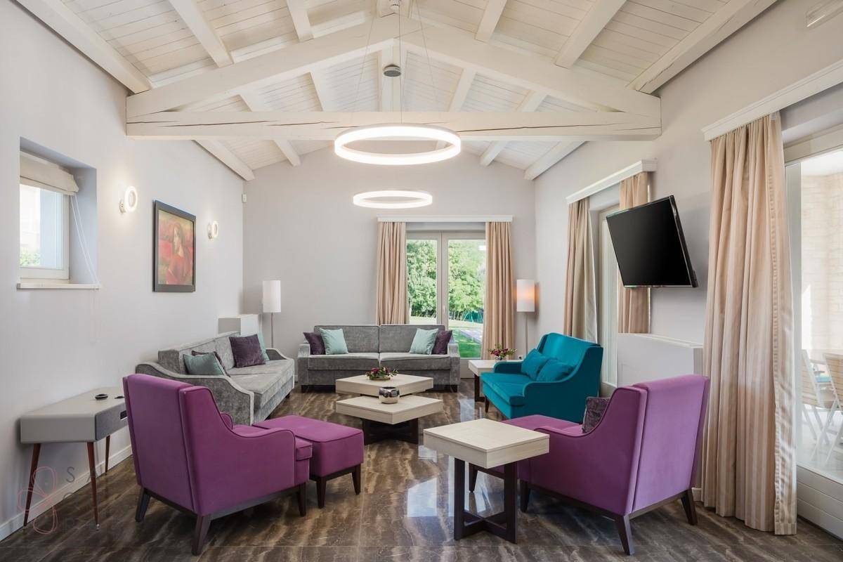 Geräumiges Wohnzimmer mit hohen Decken, modernen Möbeln und farbenfrohen Akzenten.