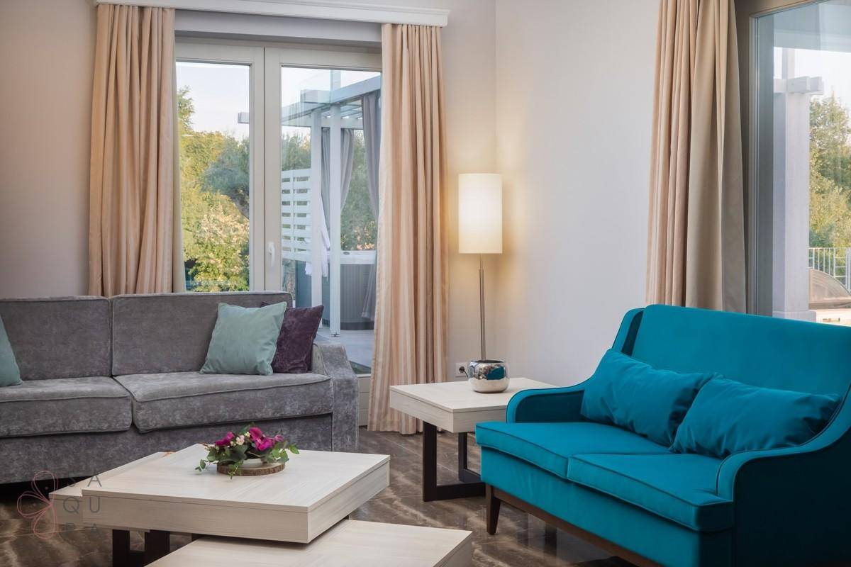 Gemütliches Wohnzimmer mit bequemen Sofas und Zugang zur Terrasse mit Whirlpool.
