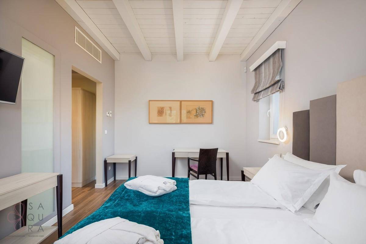 Helles Schlafzimmer mit Holzbalkendecke, Schreibtisch und stilvoller, moderner Einrichtung.