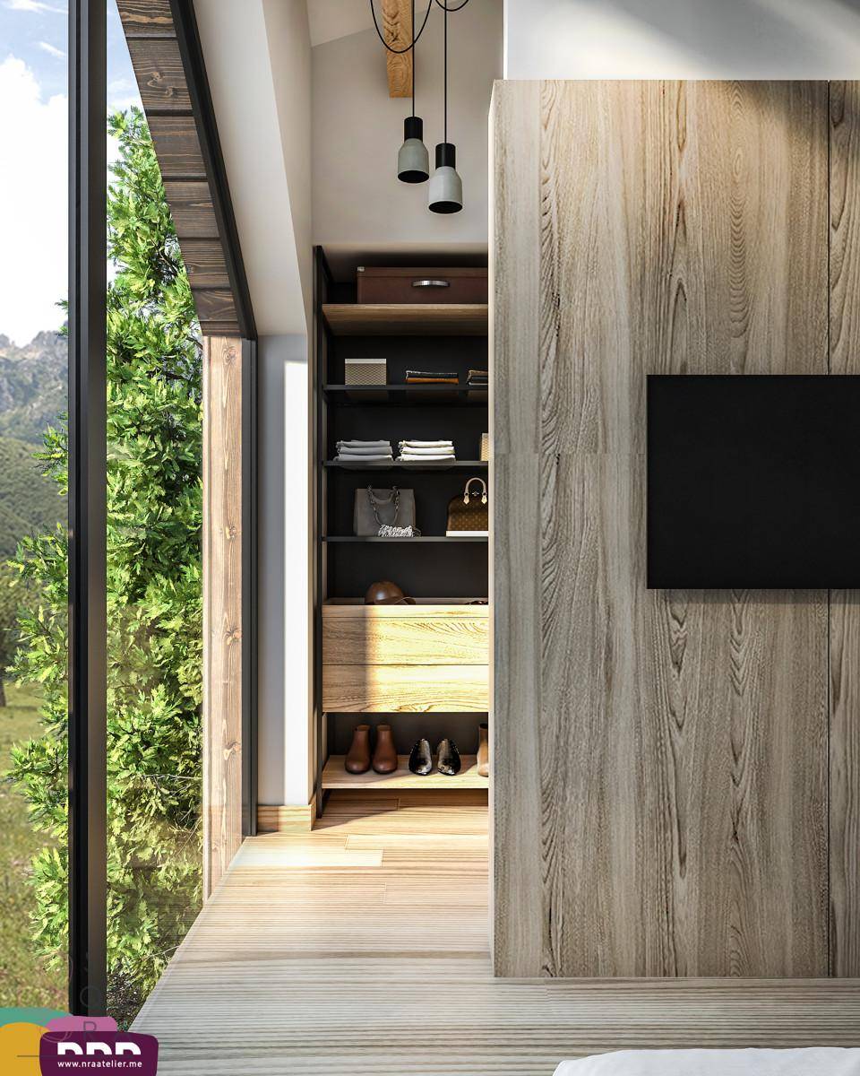Schlafzimmer mit offenem Kleiderschrank und großem Fenster mit Blick auf die Natur.