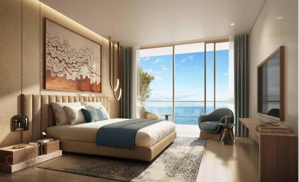 Helles Schlafzimmer mit Meerblick, großem Bett und direktem Zugang zum Balkon.