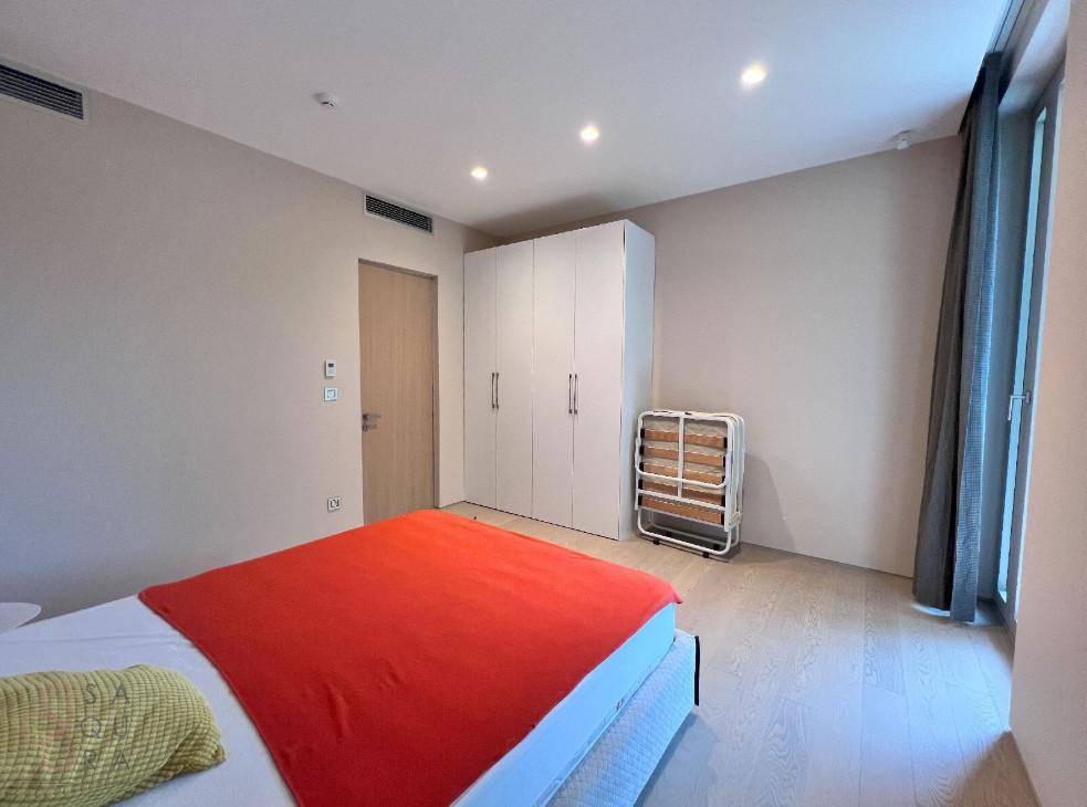 Modernes Schlafzimmer mit Einbauschränken, Holzboden und indirekter Deckenbeleuchtung.
