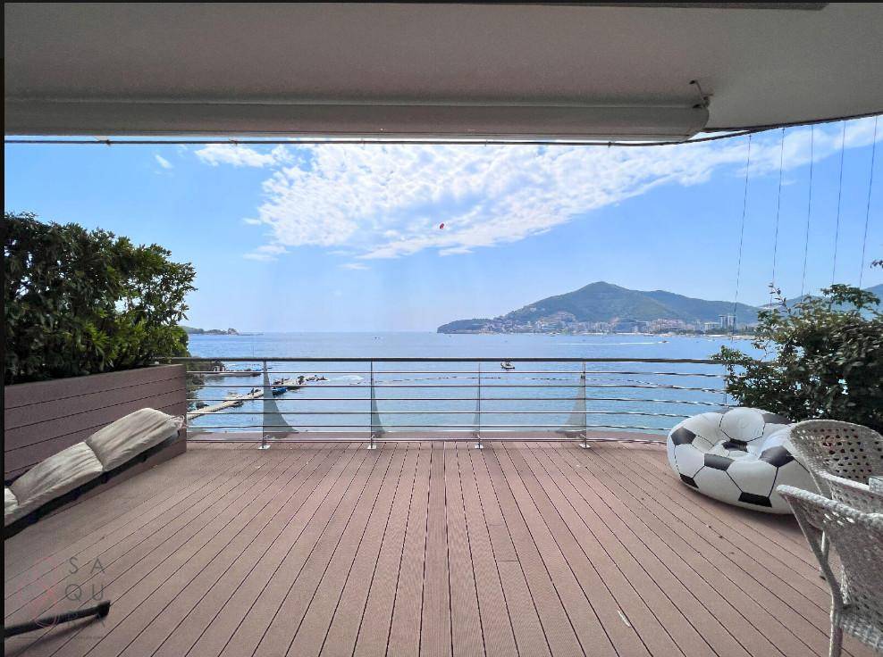 Große Terrasse mit Meerblick, Holzdeck und bequemen Outdoor-Möbeln.