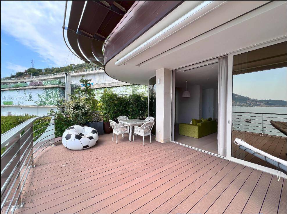 Geräumige Terrasse mit Meerblick, Essbereich und Zugang zum Wohnbereich.