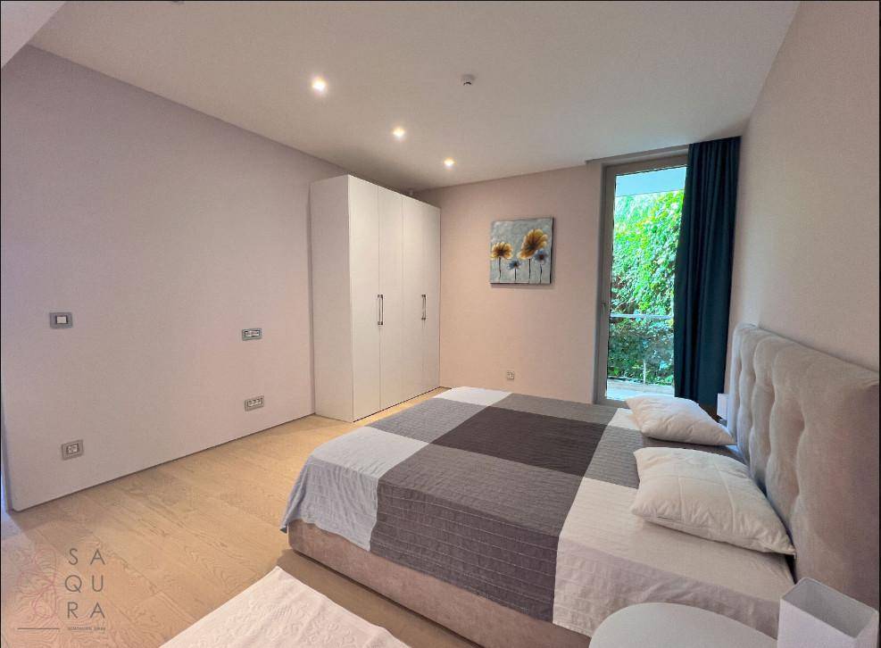 Helles Schlafzimmer mit modernem Bett, Einbauschränken und Zugang zum Außenbereich.