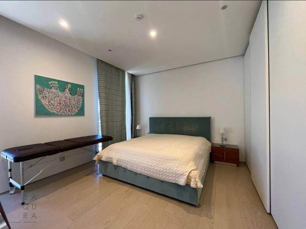 Helles Schlafzimmer mit Doppelbett, Holzboden und integriertem Wandschrank.