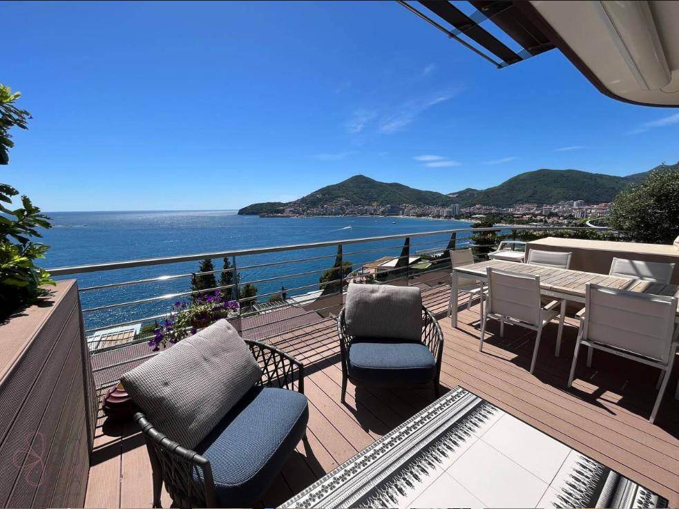 Geräumige Terrasse mit Panoramablick auf das Meer, die Berge und die Küstenstadt.