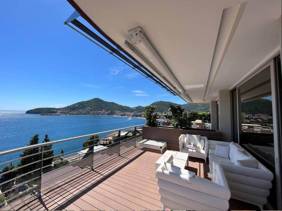 Große Terrasse mit weißen Lounge-Möbeln und beeindruckendem Blick auf die Küste und das Meer.