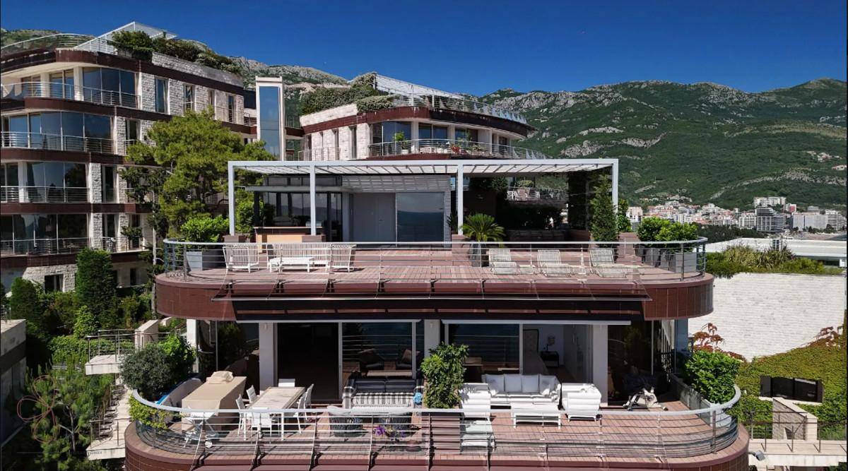 Großzügige Terrasse mit modernen Outdoor-Möbeln und weitem Blick auf die Berge und das Meer.