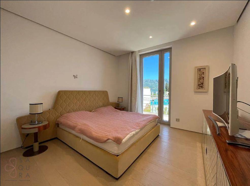 Schlafzimmer mit großem Fenster, das viel Tageslicht hereinlässt und Blick nach draußen bietet.