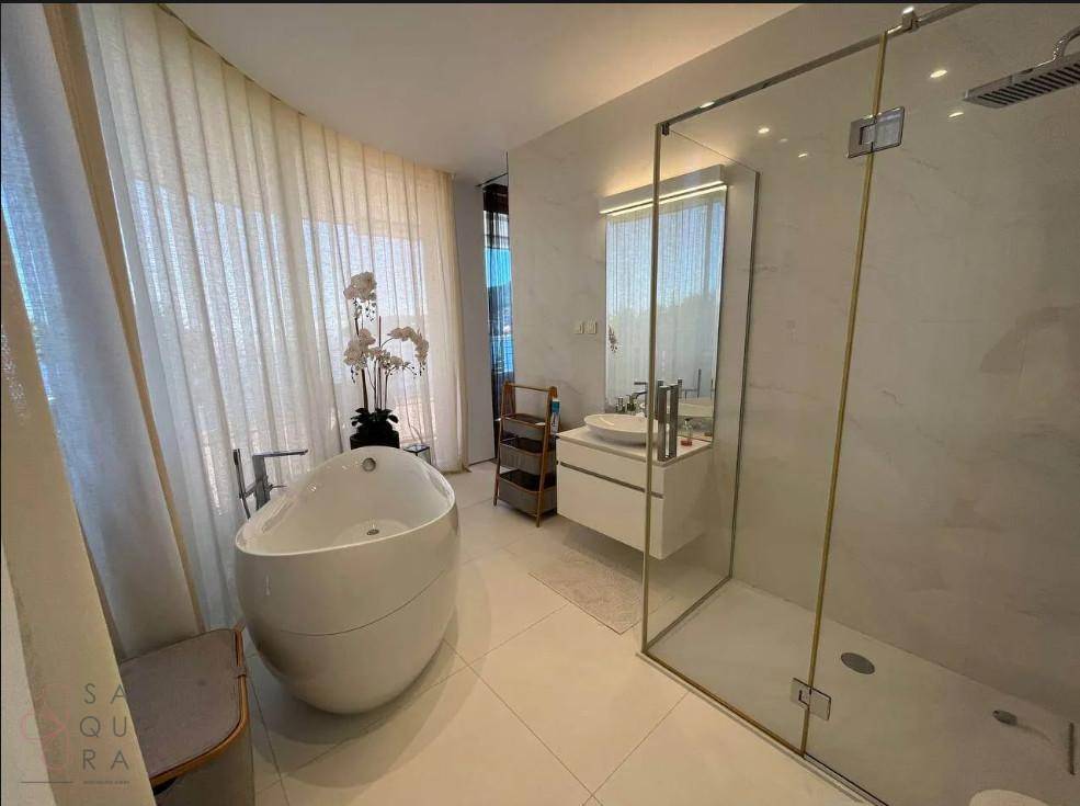 Luxuriöses Badezimmer mit freistehender Badewanne, begehbarer Dusche und großen Fenstern.