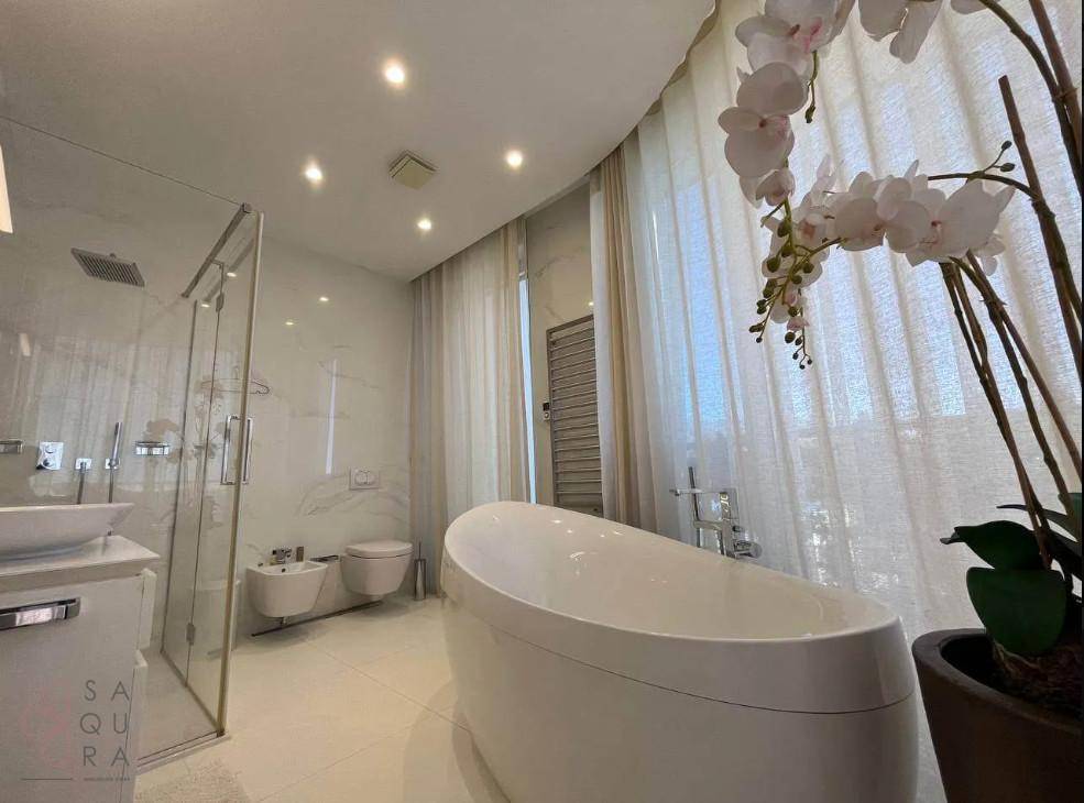 Elegantes Badezimmer mit freistehender Badewanne, Bidet und modernen Armaturen.