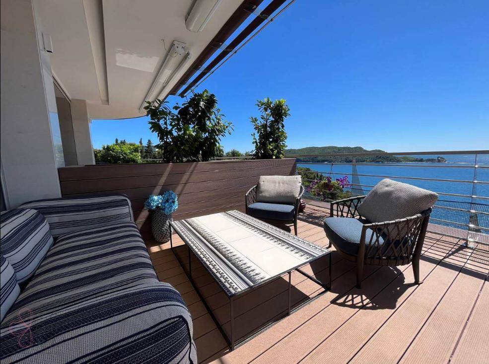 Sonnenterrasse mit bequemen Lounge-Möbeln und weitem Blick auf das Meer und die Küste.