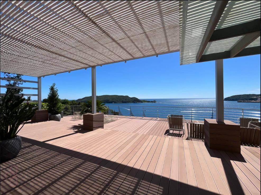 Weitläufige Terrasse mit Pergola, Holzboden und atemberaubendem Blick auf das Meer.