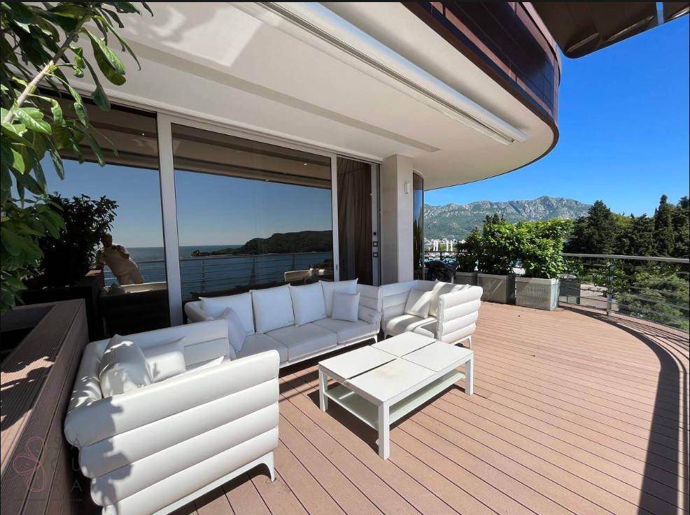 Geräumige Terrasse mit modernen Lounge-Möbeln und Panoramablick auf das Meer und die Berge.