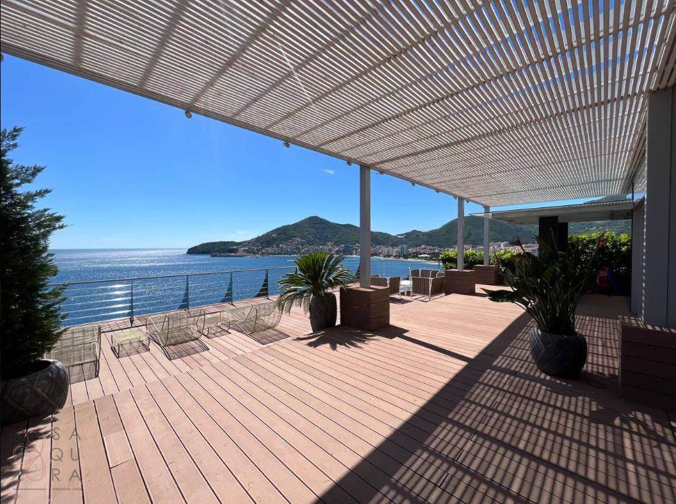 Großzügige Terrasse mit Panoramablick auf das Meer und die Küste, ausgestattet mit Liegemöglichkeiten.